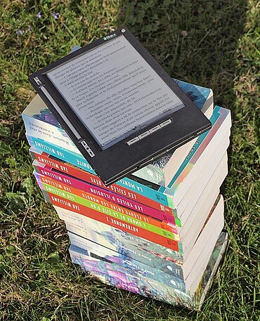 Ein E-Book-Reader auf einem Bücherstapel