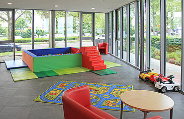 Raum mit Spielautos, Spielteppich und Bällebad