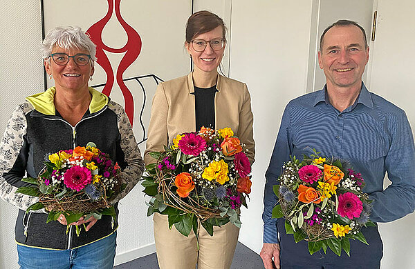 Oberbürgermeisterin Katrin Albsteiger, Christine Vietzen und Herbert Blessing mit bunten Blumensträußen