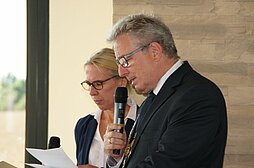 OB Noerenberg spricht am Rednerpult in eine Mikrophon, neben ihm eine Frau mit Mikrophon