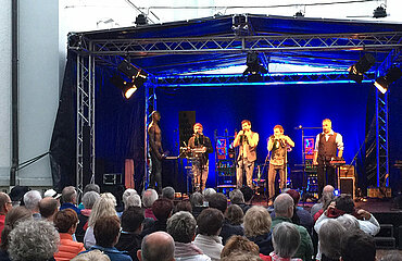 Konzert einer Band auf einer Bühne vor Publikum