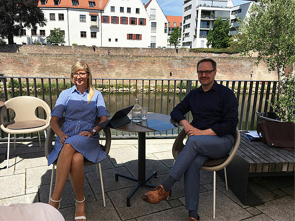 Oberbürgermeisterin Katrin Albsteiger und Landrat Thorsten Freudenberger sitzend an einem Tisch am Neu-Ulmer Donauufer