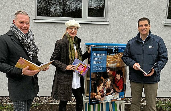 Oberbürgermeisterin Katrin Albsteiger, SWU-Geschäftsführer Klaus Eder (rechts im Bild) und Dezernent Ralph Seiffert vor dem Bücherschrank.