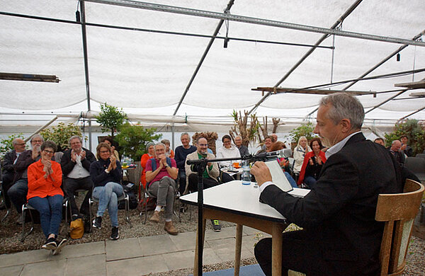 Eine Person liest vor Publikum