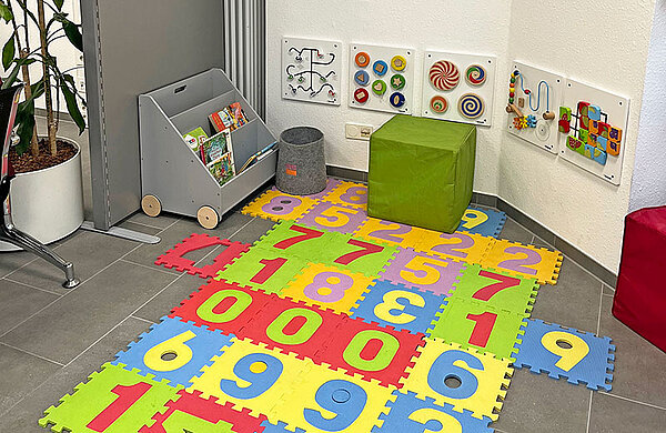 Kinderspielecke mit bunter Spielmatte, Büchern und Spielsachen