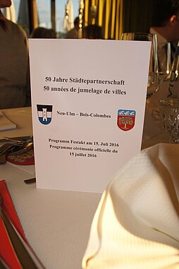 Programmkarte auf dem Tisch mit Aufschrift 50 Jahre Städtepartnerschaft Neu-Ulm - Bois-Colombes