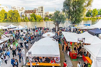 Blick von oben auf das Donaufest am Ulmer Donauufer mit Marktänden und Besuchern