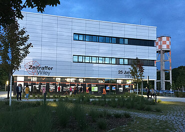 Foto von der Fassade der Hochschule Neu-Ulm mit der Ausstellung "Zeitraffer Wiley"