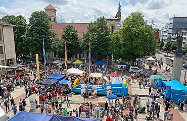 Blick vom Rathaus auf den Rathausplatz mit zahlreichen Spielstationen und Besuchern