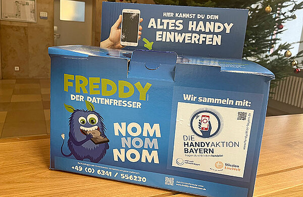 Althandy-Sammelbox mit Aufschrift "Altes Handy einwerfen"