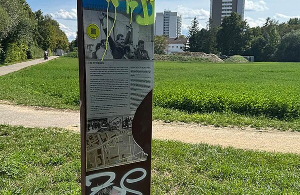 Eine beschmierte und beschädigte Infotafel