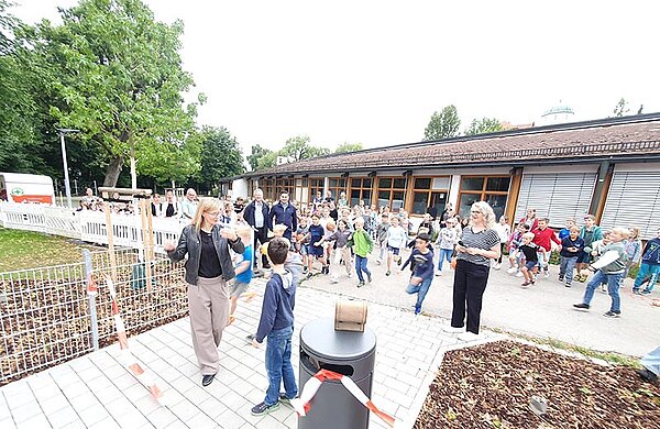 Neu-Ulms Oberbürgermeisterin Katrin Albsteiger und die Kinder der Grundschule hinter dem durchgeschnittenen Band