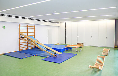 Turnraum mit Kletterwand, Trampolin und Sportmatten