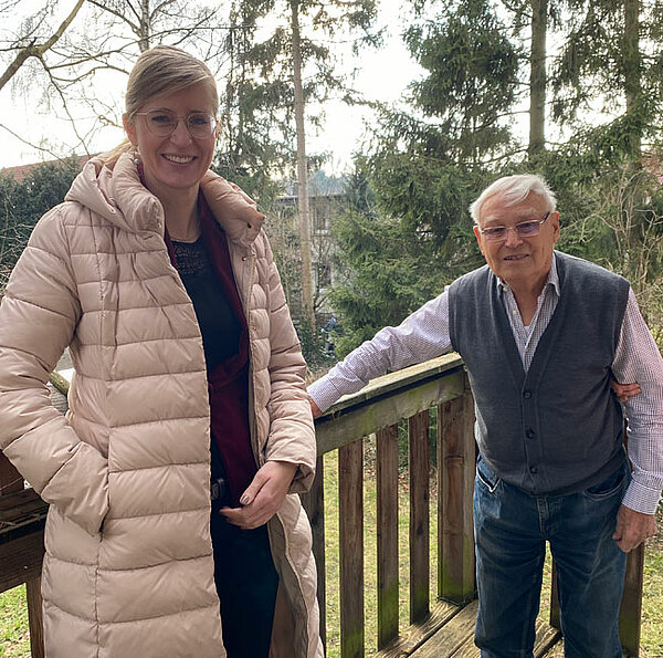 Neu-Ulms Oberbürgermeisterin Katrin Albsteiger und der Jubilar stehen im Freien auf einer Terrasse.