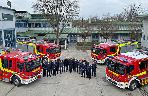 Blick von oben auf die vier Löschfahrzeuge sowie Kameraden der Feuerwehr