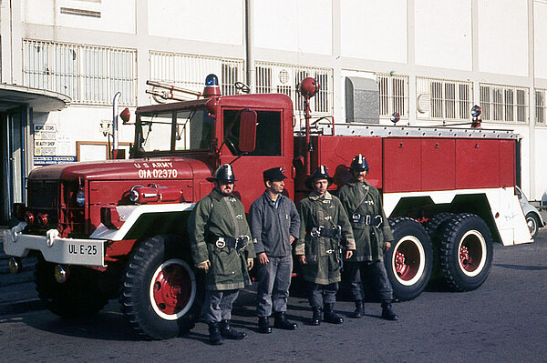 Feuerwehrleute vor einem Feuerwehrfahrzeug
