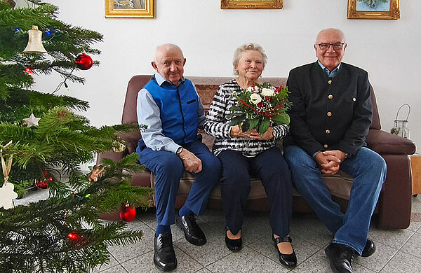 Die Eheleute und Neu-Ulms 2. Bürgermeister sitzen auf einer Couch, im Vordergrund steht ein Weihnachtsbaum.