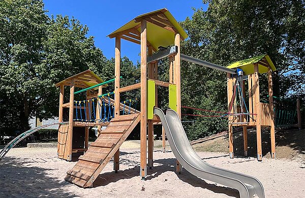 Spielkombination auf dem Spielplatz, mit Rutsche, Hängebrücke, Türmen und Kletterelementen