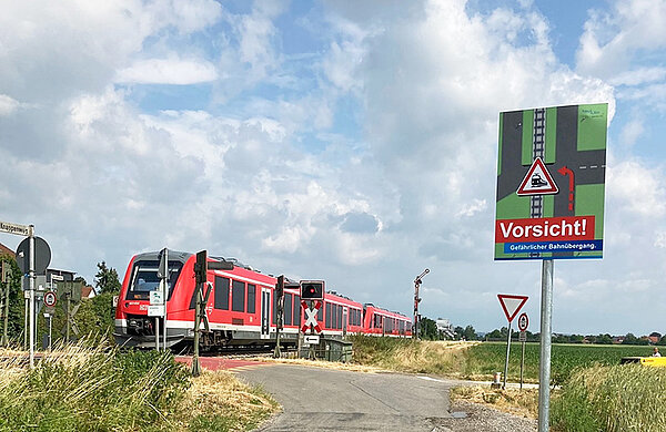 Ein Zug durchfährt einen unbeschrankten Bahnübergang