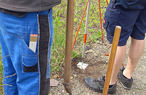 Zwei Feldgeschworene setzen einen Grenzstein