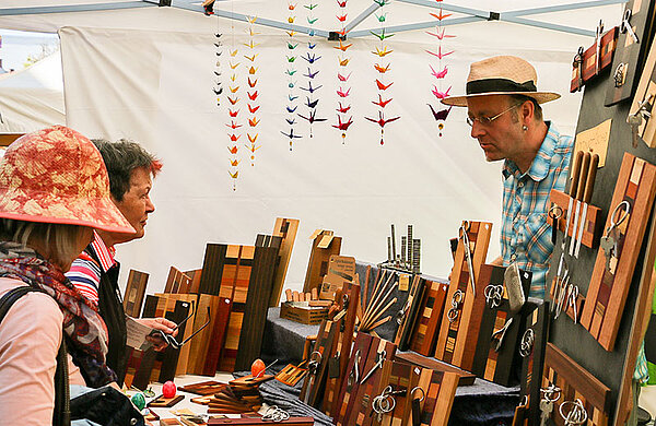 Marktstand mit Waren aus Holz und Papeterie