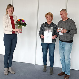 Das Ehepaar hält die Ehrenmedaille sowie eine Urkunde in den Händen, daneben Oberbürgermeisterin Katrin Albsteiger mit einem Blumenstrauß.