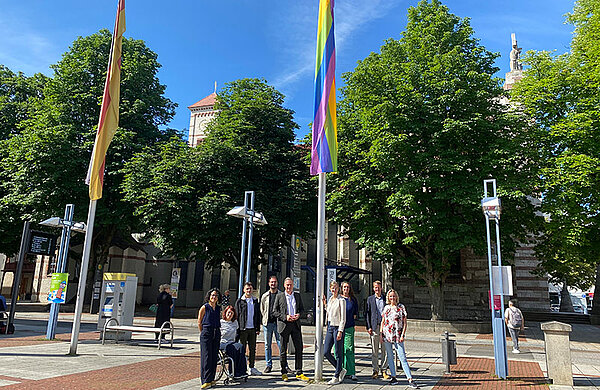 Neu-Ulms Oberbürgermeisterin und städtische Mitarbeitende neben der Regenbogenfahne am Rathausplatz