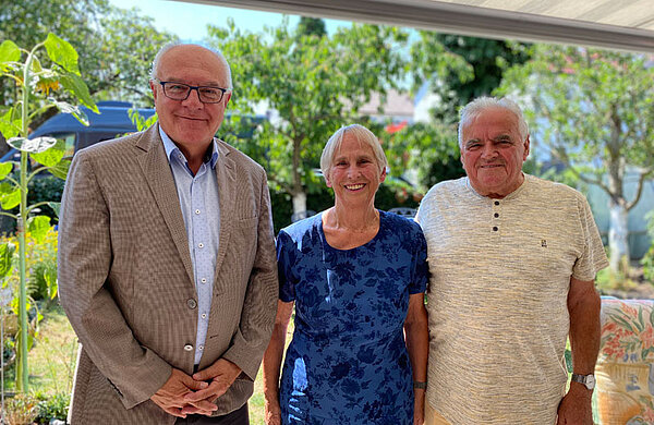 Bürgermeister Johannes Stingel steht neben dem Ehepaar Vietz in derem Garten