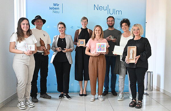 Gruppenfoto mit den Jurymitgliedern, der Oberbürgermeisterin sowie den Preisträgerinnen und Preisträgern samt ihren Wasserturm-Geschenken