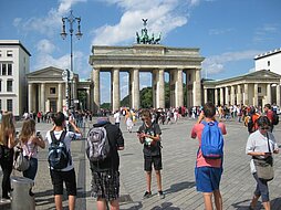 Die Jugendlichen stehen vor dem Brandenburger Tor und machen Fotos