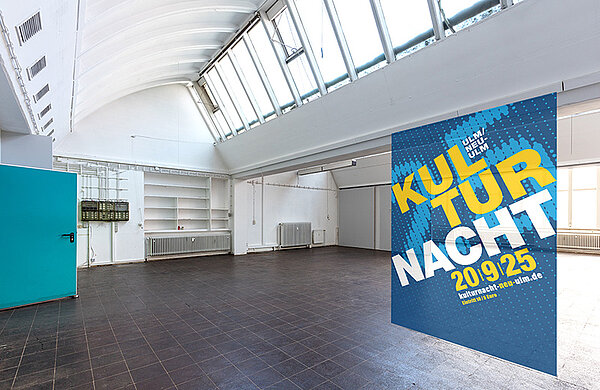 Fotocollage: Industriehalle mit Plakat zur Kulturnacht 2025
