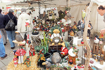 Marktstand mit Töpfer- und Keramikwaren auf dem Neu-Ulmer Töpfermarkt, im Hintergrund Marktbesucher