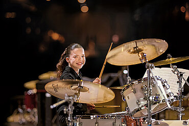 Ein Mädchen spielt Schlagzeug