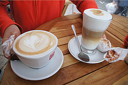 Tasse mit Cappuccino und Latte Macchiato im Glas