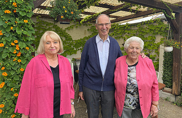 Rosl Schäufele neben dem Ehepaar Rösch vor einer Pergola