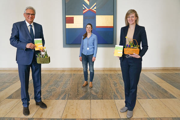 Oberbürgermeister Gunter Czisch und Oberbürgermeisterin Katrin Albsteiger halten das Taschenbuch sowie einen Korb mit Blumen in der Hand, hinter ihnen steht die Vocatium-Projektleiterin.