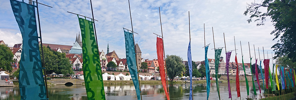 Das Ulmer und Neu-Ulmer Donauufer mit Donaufest-Fahnen, Marktständen und Besuchern