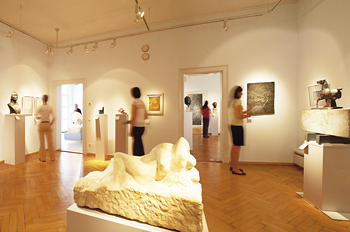 Besucher vor Ausstellungsobjekten wie Bildern und Plastiken im Edwin Scharff Museum