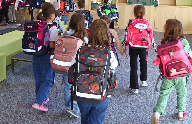 Schülerinnen und Schüler mit Schulranzen