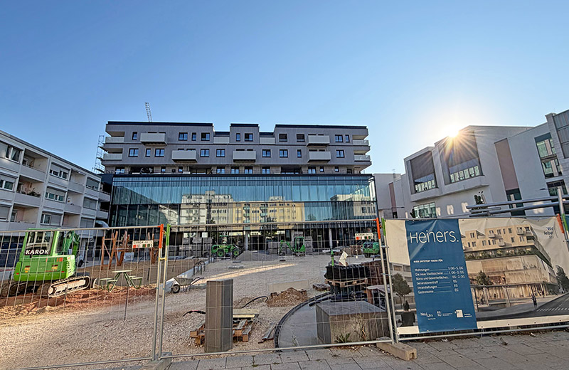Blick auf das neue Gebäude "Heiners" und die Baustelle am Heiner-Metzger-Platz