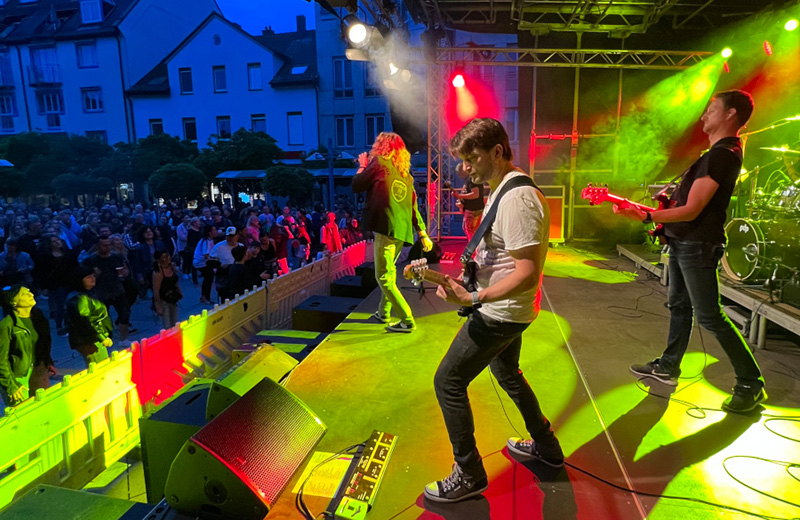 Musiker auf Bühne mit neongrünem Scheinwerferlicht