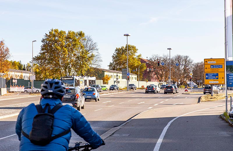 Mehrere Autos und ein Radfahrer fahren Richtung Kreuzung Memminger Straße / B10.