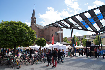 Petrusplatz mit Marktständen und Marktbesuchern, im Hintergrund die Petruskirche