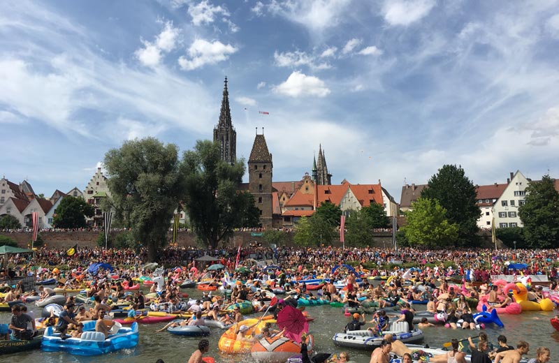 Nabada vor der Ulmer Skyline mit tausenden "Nabader", die auf Booten, Flößen und Luftmatratzen die Donau "hinunterbaden".