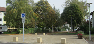 Stadtteilplatz in Offenhausen, im Hintergrund Wohnbebauung und Bäume