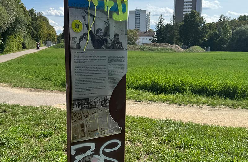 Eine beschmierte und beschädigte Infotafel