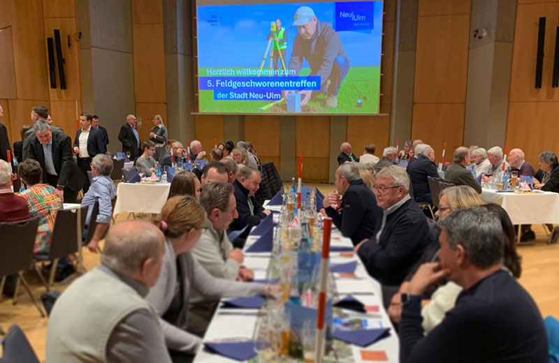 Feldgeschworenentreffen im großen Saal des Edwin-Scharff-Hauses: Die Gäste sitzen an Tischen und unterhalten sich.