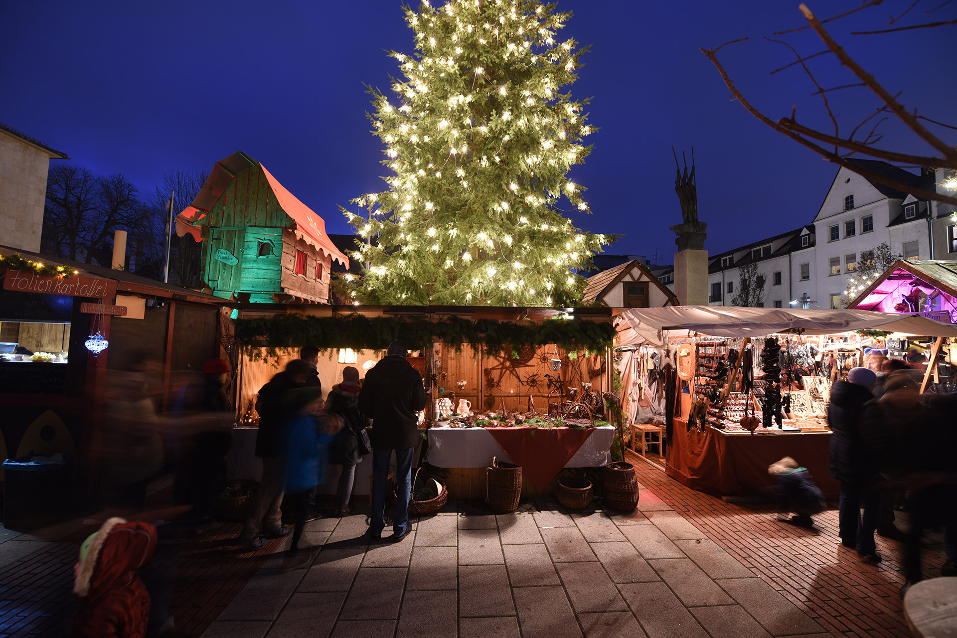 Weihnachtsmarkt mit Marktständen und beleuchtetem Weihnachtsbaum