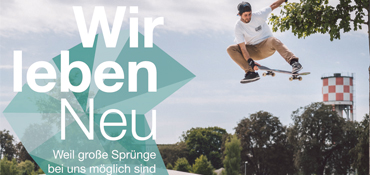 Ein Skateboarder springt mit seinem Skateboard in die Luft, im Hintergrund der Wasserturm im Neu-Ulmer Wiley und links im Bild der Text "Wir leben Neu - Weil große Sprünge bei uns möglich sind"