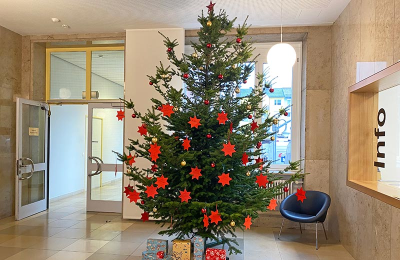 Weihnachtsbaum mit Weihnachtsbaumkugeln und Papiersternen